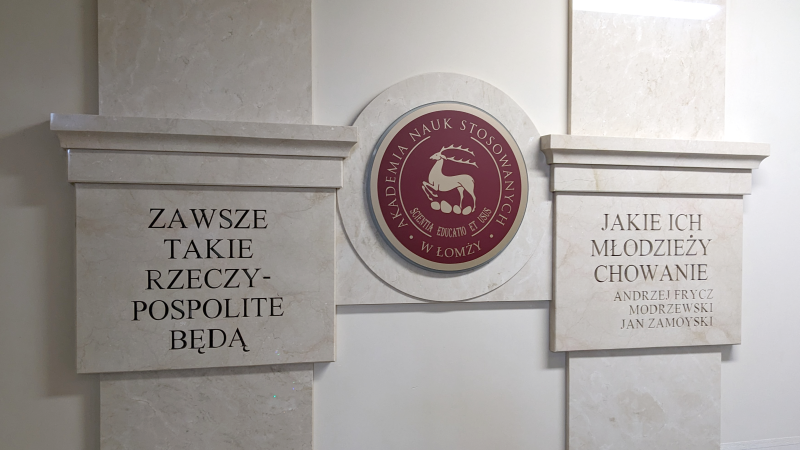 Ściana z logo uczelni i napisem Zawsze takie Rzeczypospolite będą, jakie ich młodzieży chowanie Andrzej Frycz Modrzejewski, Jan Zamoyski